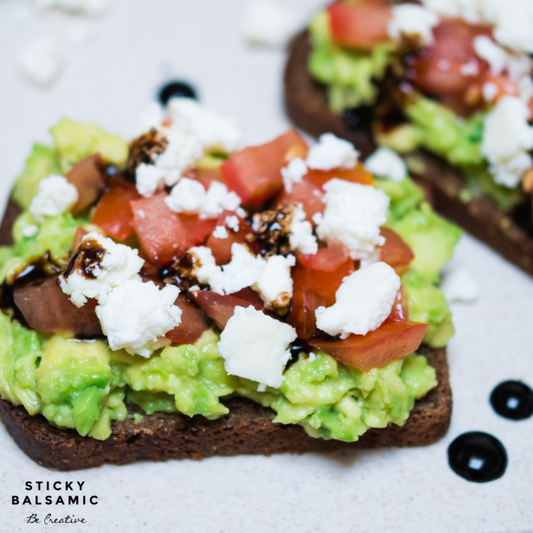 Smashed avocado, tomato, cheese on sourdough toast with sticky balsamic drizzled on the top