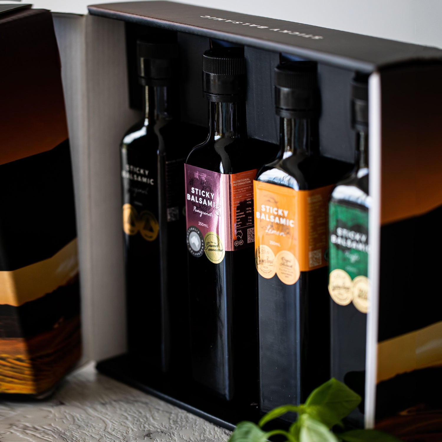 Balsamic bottle gift box with dark bottles standing in an open black-lined box