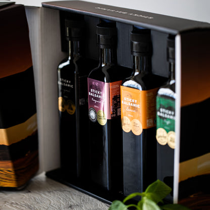 Balsamic bottle gift box with dark bottles standing in an open black-lined box