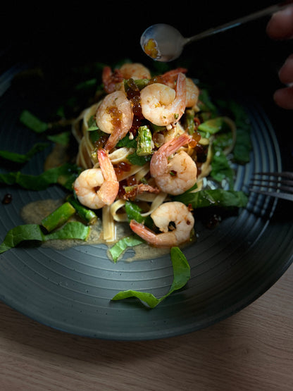 Shrimp salad with dark pomegranate pearls on leafy greens in a bowl