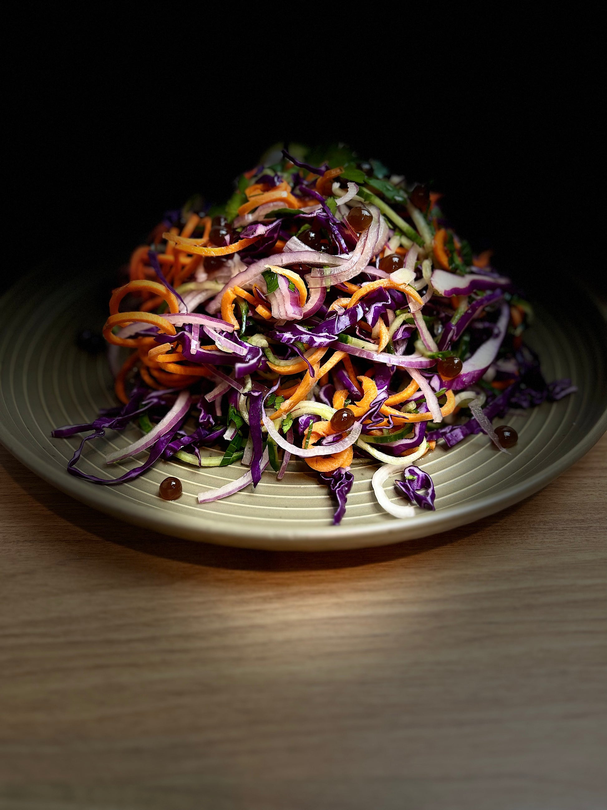 Shredded vegetable salad in a bowl with purple and orange strands