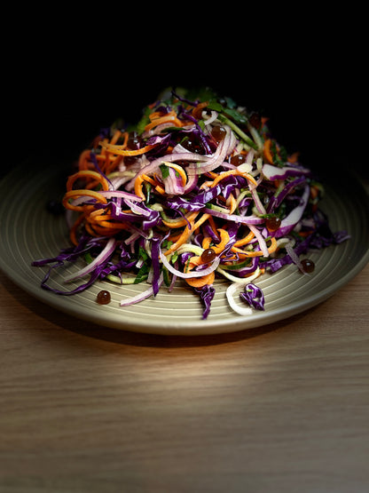 Shredded vegetable salad in a bowl with purple and orange strands