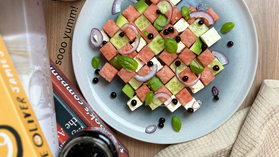 Sticky balsamic pearls topping on salad plate with watermelon cubes and greens
