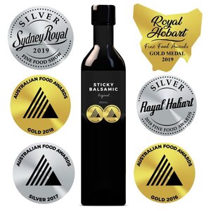 Black BBQ sauce bottle with branded gold and silver seals