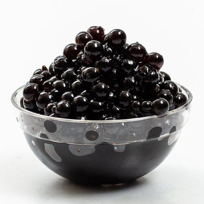 Glass bowl of glossy black sticky balsamic pearls