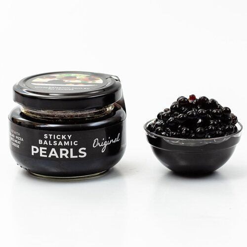 Sticky balsamic pearls jar and small bowl filled with glossy black pearls